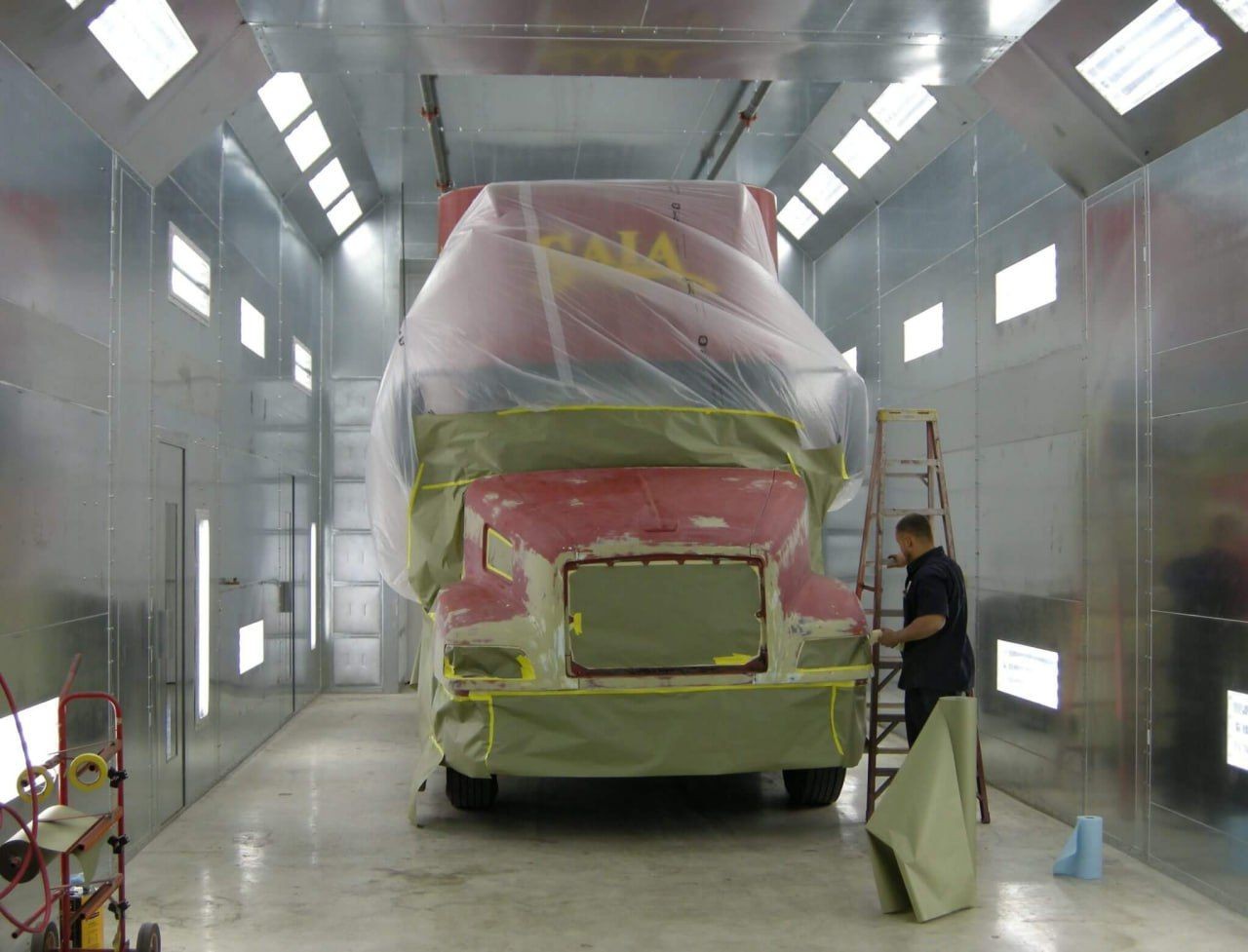 Mechanic working on a truck body at our East Dundee shop, performing precise body work and restoration for a truck in need of repairs